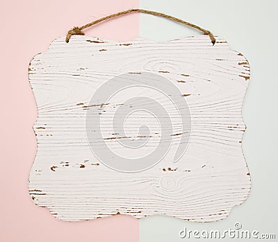 Blank wooden carved hanging on a blue and pink background Stock Photo