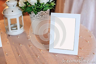 Blank wooden picture frame decoration on table decorated by white tablecloth. Wedding reception ceremony, anniversary celebration Stock Photo