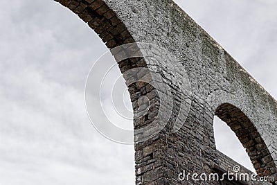 Bleak view of grey skies seen through old stone archways, vintage architectural ruins Stock Photo