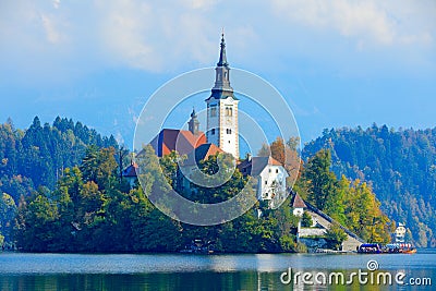 Bled lake island, St Martin Catholic church and Castle. Landscape in Slovenia, nature in Europe. Foggy Triglav Alps with forest, Stock Photo