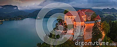 Bled, Slovenia - Aerial panoramic view of illuminated Bled Castle Blejski Grad with Pilgrimage Church of the Assumption of Maria Stock Photo