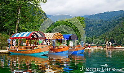 A pier on the island of Lake Bled with traditional Slovenian boats Editorial Stock Photo