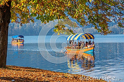 BLED, SLOVENIA - October 9, 2018: People tourists sliding on still waters in boats Editorial Stock Photo