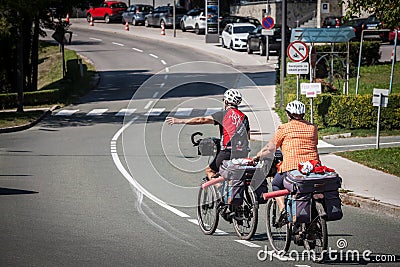 Selective blur on a senior couple riding bicycle doing bike touring in bled, in the alps, with luggage on the bicycle, Editorial Stock Photo