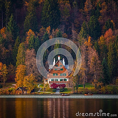Bled, Slovenia - Typical Slovenian alpen house by the Lake Bled with boats and beautiful colorful autumn forest Stock Photo