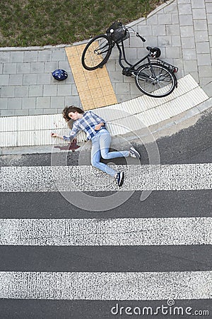 Bleeding car crash victim next to bike Stock Photo