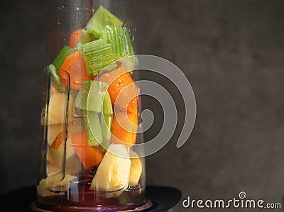 Blender with fresh vegetables. Sliced celery, apple and carrot in a blender cup for a smoothie. Healthy food. raw food. Gray Stock Photo