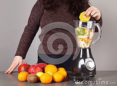 Blender, woman, fruits and gray background Stock Photo