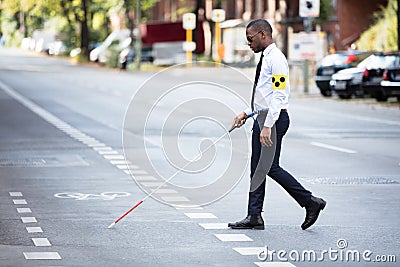Blind Man Wearing Armband Walking With Stick Stock Photo