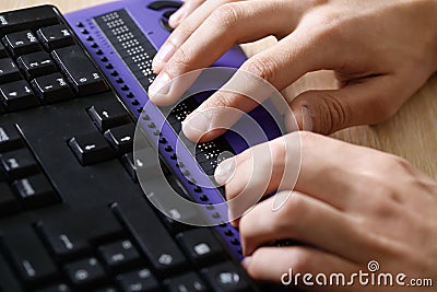 Blind person using computer with braille computer display Stock Photo