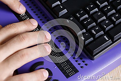 Blind person using computer with braille computer display Stock Photo