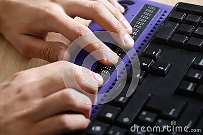 Blind person using computer with braille computer display Stock Photo