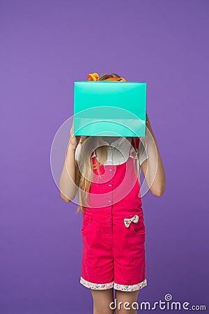 Blind of shopping. Kid holds package in front of face. Simple reminders how to shop smart. Girl cute teenager carries Stock Photo
