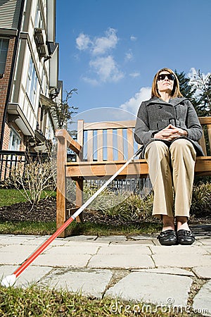 Blind woman sitting on a bench Stock Photo