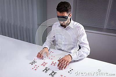 Blindfolded Businessman Reading Cards In Office Stock Photo