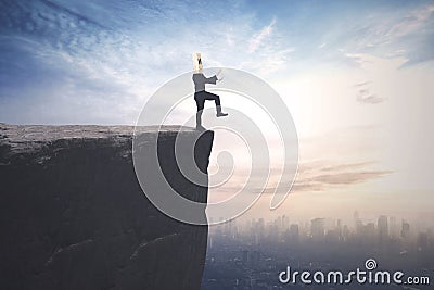 Blindfolded businessman walks on the cliff Stock Photo