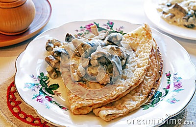 Blini with mushrooms in white sauce Stock Photo