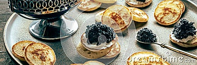 Blinis with black caviar panorama. Mini pancakes on a festive dish Stock Photo