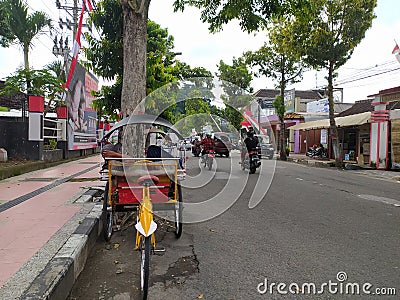 Blitar, Indonesia, March 17, 2022. Pedicab drivers wait for customers on the side of the road shopping at a traditional market. Editorial Stock Photo