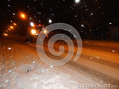 A truck with plow cleans the snow on the road Stock Photo