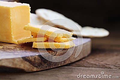 Block of Cheddar Cheese with Slices Stock Photo