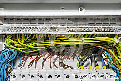 Block connecting green-yellow grounding wires with connected cables, installed in electrical box. Stock Photo