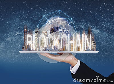 Blockchain business and technology, Hand holding digital tablet with buildings and blockchain technology. Element of this image ar Stock Photo