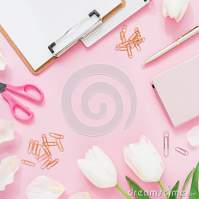 Blogger concept with copy space. Frame with tulips flowers, scissors and clipboard, clips on pink background. Flat lay, top view. Stock Photo