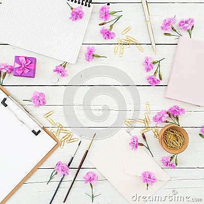 Blogger or freelancer workspace with clipboard, notebook, pink flowers and accessories on rustic wooden rustic background. Beauty Stock Photo