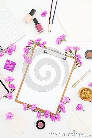 Blogger or freelancer workspace desk with clipboard, notebook, pink flowers and accessories on white background. Beauty blog conce Stock Photo