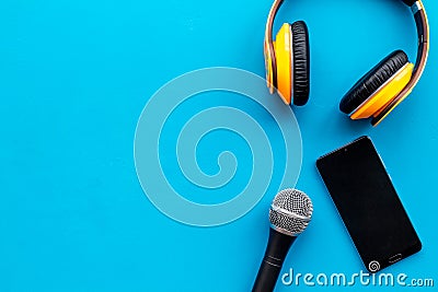 Blogger, journalist or musician work space with microphone, telephone and headphones on blue background top view mock-up Stock Photo