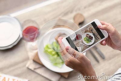 Blogger taking photo of food with mobile phone Stock Photo