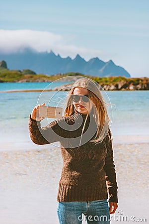 Blogger woman taking selfie photo by smartphone camera influencer girl traveling in Norway Stock Photo