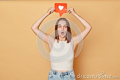 Blogging communication. Heart icon click. Online community interaction. Surprised excited brown haired young woman wearing casual Stock Photo