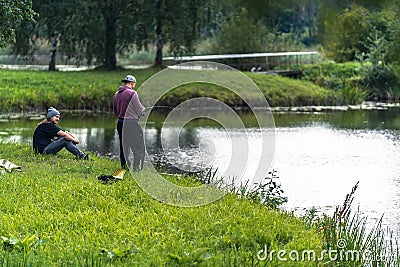 Blome / Latvia - August 20th, 2018: Photo of Two Millennials Fishing - Spending Quality Leisure Time Editorial Stock Photo