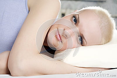 blond bald woman lying on the bed Stock Photo