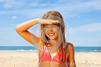 Blond girl with hand near elbow shading from sun Stock Photo