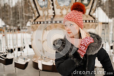 Blond girl in winter clothes red cap and mittens. Walk in the park Stock Photo