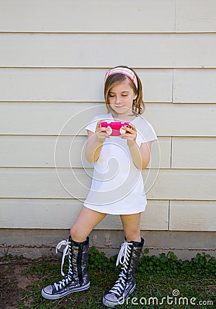 Blond little fashion kid girl playing with smartphone Stock Photo