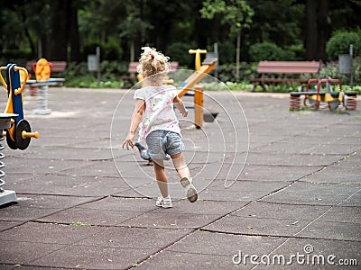 Blond little girl running in the playground Stock Photo