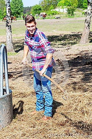 Blond man at farmland holdiing pitchfork Stock Photo