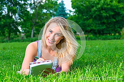 Blond posing in a park lying on the lawn Stock Photo