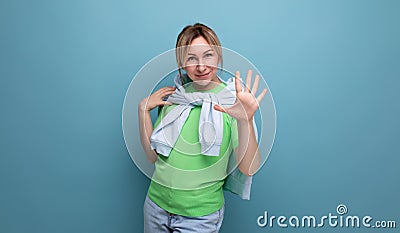 blond positive bright girl in casual outfit shows five fingers on a blue background with copy space Stock Photo