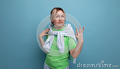 blond positive bright girl in a casual outfit shows three fingers on a blue background with copy space Stock Photo