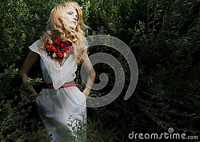 Blond pretty girl in green bushes dreaming Stock Photo