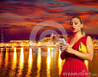 Blond tourist girl smartphone chat in Ibiza sunset Stock Photo