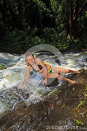 Blond woman in bikini by waterfall Stock Photo