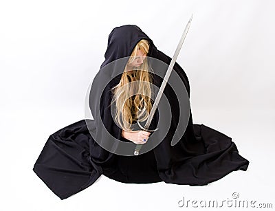 Blond woman in black hooded cloak with sword Stock Photo