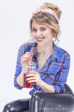 Blond Woman in latex pants Posing with Cup of Red Juice and Straw. Stock Photo