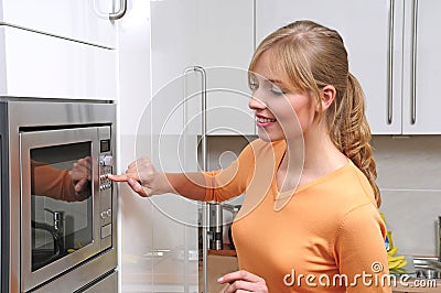 Blond woman with a microwave Stock Photo